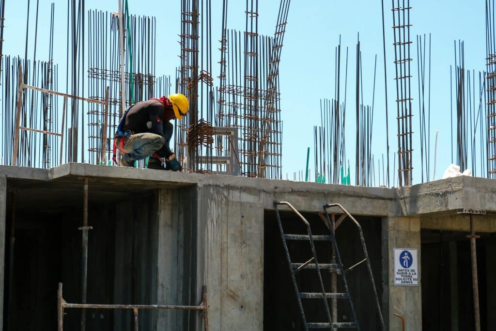 2025最新容積獎勵政策解析:如何讓老屋改建更划算? 2 man kneeling on unfinished building during daytime